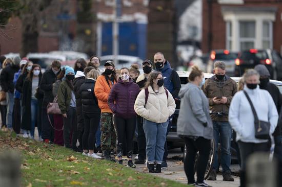 11月6日，人们在英国利物浦的一处新冠病毒检测点排队等待检测。
